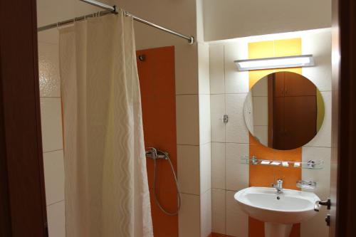 Morávka的住宿－水壩酒店，浴室配有盥洗盆和带镜子的淋浴