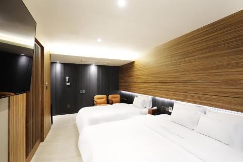 a hotel room with two beds and a television at Hotel Sol -The Ryokan and Sauna in Jeonju