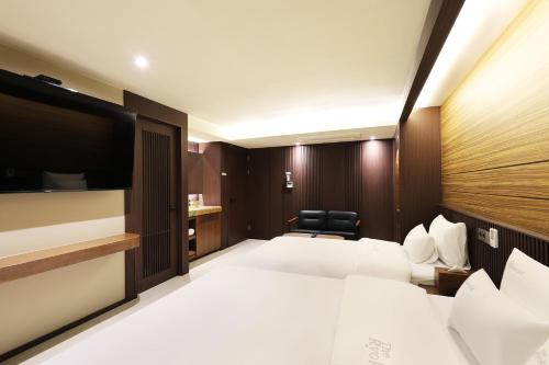 a hotel room with two beds and a flat screen tv at Hotel Sol -The Ryokan and Sauna in Jeonju