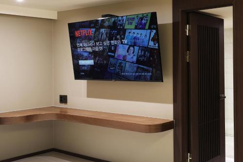 a flat screen tv hanging on a wall at Hotel Sol -The Ryokan and Sauna in Jeonju