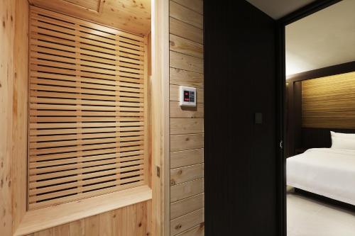 a bedroom with a bed and a wooden wall at Hotel Sol -The Ryokan and Sauna in Jeonju