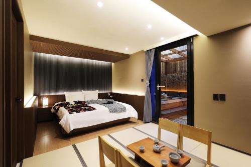 a bedroom with a bed and a dining room with a table at Hotel Sol -The Ryokan and Sauna in Jeonju