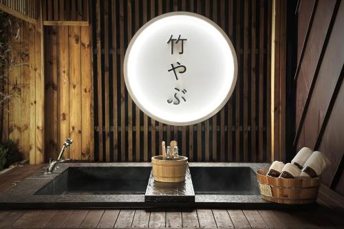 a clock on the wall above a bath tub at Hotel Sol -The Ryokan and Sauna in Jeonju