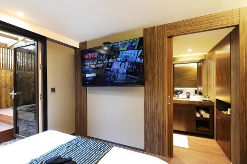 a bedroom with a large flat screen tv on the wall at Hotel Sol -The Ryokan and Sauna in Jeonju