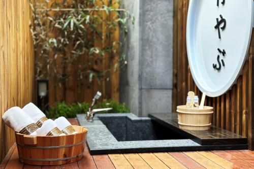 a bathroom with a sink and a clock on a wall at Hotel Sol -The Ryokan and Sauna in Jeonju