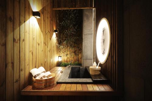 a room with a tub and a clock on the wall at Hotel Sol -The Ryokan and Sauna in Jeonju
