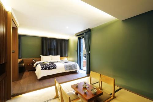 a bedroom with a bed and a table and chairs at Hotel Sol -The Ryokan and Sauna in Jeonju