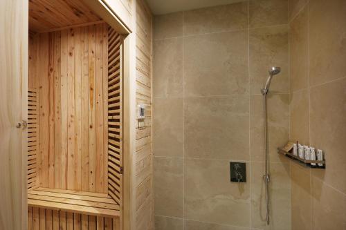a bathroom with a shower with a wooden wall at Hotel Sol -The Ryokan and Sauna in Jeonju