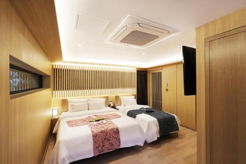a hotel room with two beds and a television at Hotel Sol -The Ryokan and Sauna in Jeonju