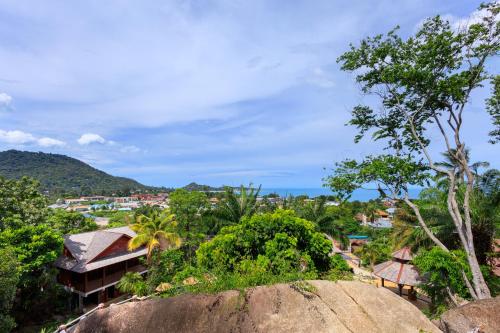 a view of a city from a hill with trees at Samui Wooden Hill Resort in Lamai