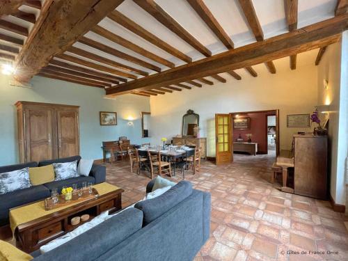 un salon avec un canapé bleu et une table dans l'établissement Manoir du XVème siècle : charme, piscine, cheminée, jeux, proche forêt, idéal famille. - FR-1-497-204, à Colombiers