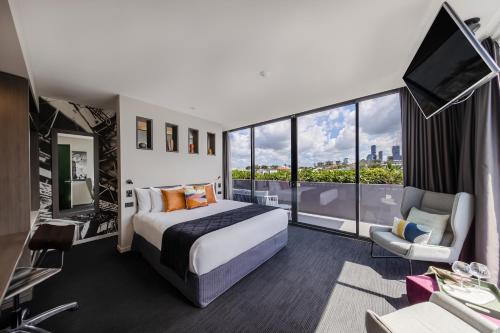 a hotel room with a bed and a large window at Sage Hotel James Street in Brisbane