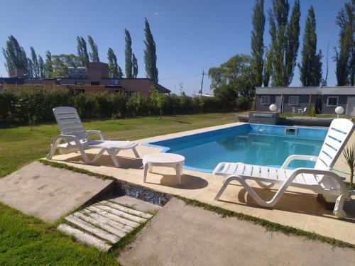 圣拉斐尔Brisa de montaña的两把躺椅和一个位于庭院的游泳池