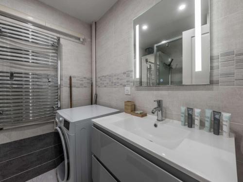 une salle de bain avec un lavabo blanc et un miroir dans l'établissement Appartement 40m² - 4 personnes - Courchevel Moriond - Skis aux pieds - FR-1-631-192, à Courchevel