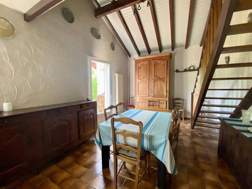 une cuisine avec une table et des chaises dans une pièce dans l'établissement Maison spacieuse à Macaye, au calme, 6-8 pers, proche Cambo, animaux admis, jardin, internet WiFi - FR-1-495-141, à Macaye