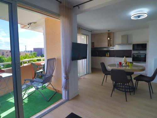 une cuisine et une salle à manger avec une table et des chaises dans l'établissement Confortable T3 avec PK privé, climatisation et accès direct à la plage - FR-1-472-201, à Sète