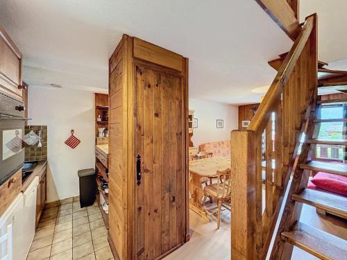 une cuisine avec une porte en bois et une table dans l'établissement Chalet à Chamonix, 54m², 3 chambres, 6 personnes - 16 Clos des Outannes, 74400 Chamonix-Mont-Blanc - FR-1-507-79, à Chamonix-Mont-Blanc