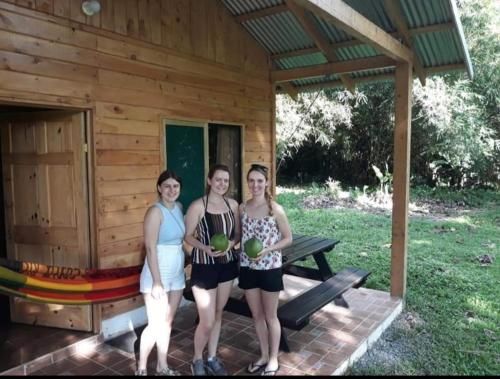 three women standing in front of a cabin at Into the Greens in Madre de Dios