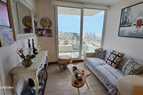 a living room with a couch and a table at Bello Dpto Lomas del Mar, Concón in Concón