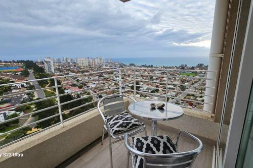 a balcony with a table and chairs and a view of a city at Bello Dpto Lomas del Mar, Concón in Concón