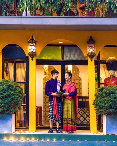 two people standing in front of a building at Yellow Lamoon Hotel in Chiang Mai