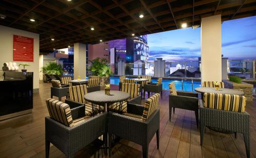 a restaurant with tables and chairs and a view of the city at Swiss-Belinn Tunjungan Surabaya in Surabaya