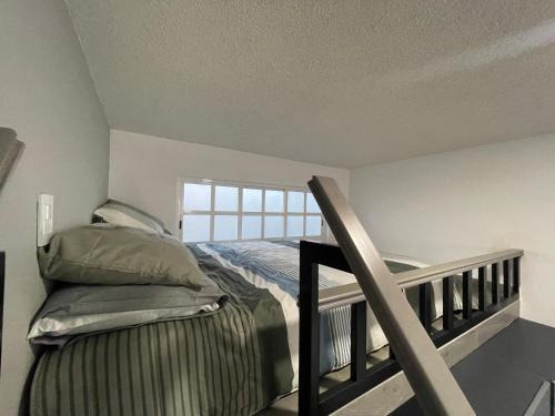 a bedroom with a bed and a stair railing at Loft a 5 minutos de Plaza de Toros in Pachuca de Soto