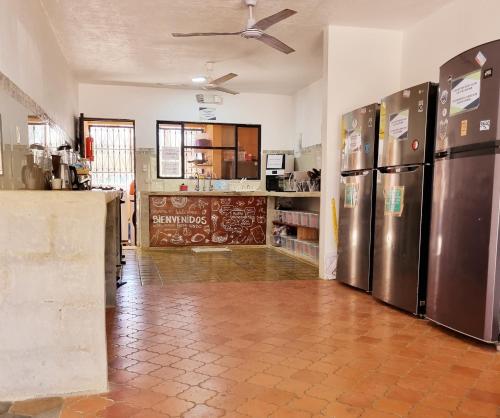 a kitchen with stainless steel refrigerators in a room at Casa Pura Vida Surf Hostel - Tamarindo Costa Rica in Tamarindo