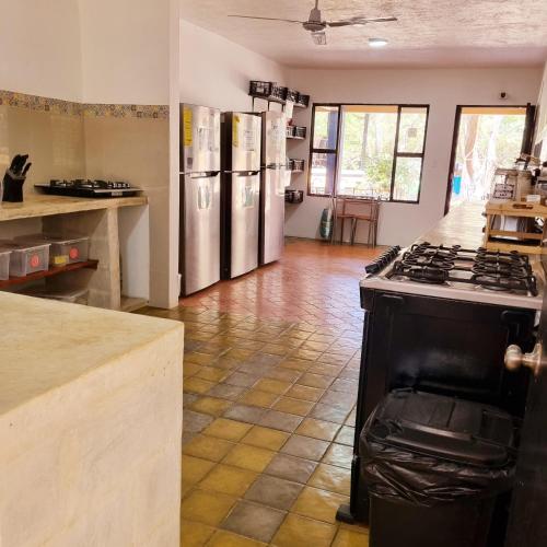 a kitchen with stainless steel refrigerators and a stove at Casa Pura Vida Surf Hostel - Tamarindo Costa Rica in Tamarindo