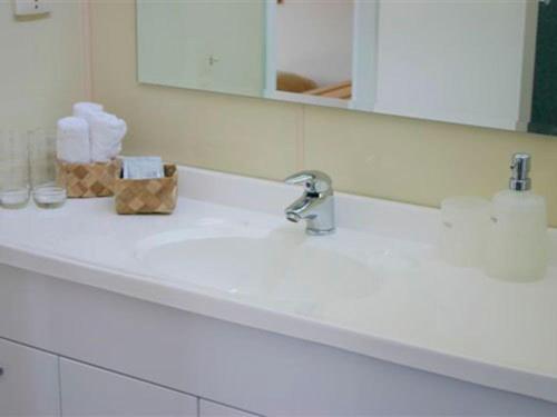a bathroom counter with a sink and a mirror at Apostles View Motel in Greymouth