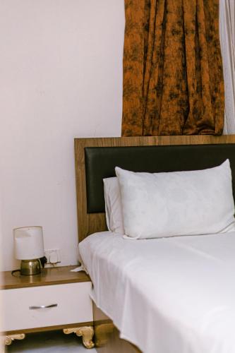 a bedroom with a bed and a night stand with a lamp at RabiAmar's in Jamisa
