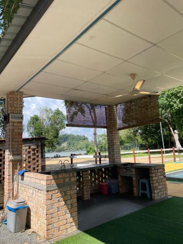 a brick barbecue grill under awning in a park at Rajawali Riverside Retreat in Dungun