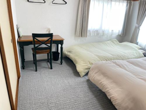 a bedroom with a desk and a bed and a chair at Azumi Relax Lodge201 in Azumino