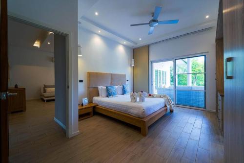 a bedroom with a large bed and a large window at Modern 3 Bedroom Pool Villa - MR54 in Hua Hin