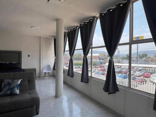 a living room with black curtains and a large window at Encantador Estudio Céntrico con Terraza Privada in Acuitlapilco