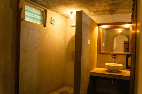 a bathroom with a sink and a mirror at Surya Lagoon Village in Nilaveli