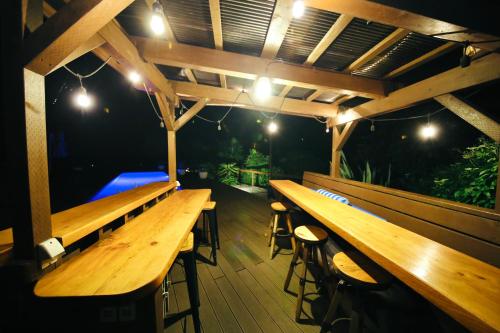 a wooden deck with benches and lights on it at コースタルキャビン - シービュー バーベキュー ピザ サウナ プール ホットタブ - Coastal Cabin Chiba - Seaview BBQ PIzza Sauna Pool Hot-tub in Iwada