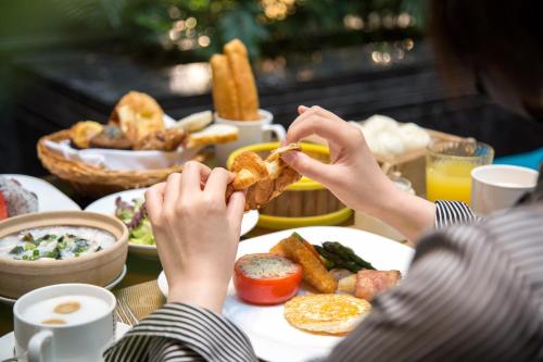 a person sitting at a table with a plate of food at InterContinental Century City Chengdu in Chengdu