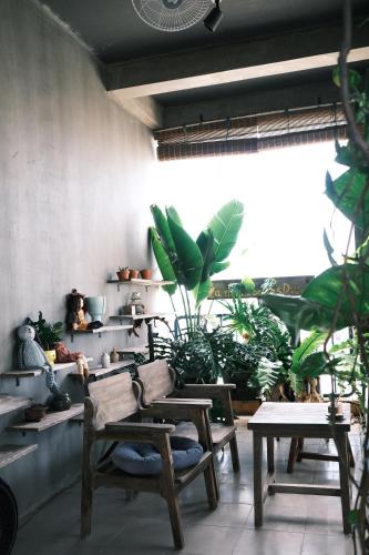 a room with tables and potted plants on shelves at La Maison Des Délices in Da Nang