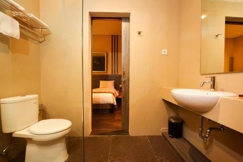 un bagno con servizi igienici e lavandino e una camera da letto di Super 8 by Wyndham Solo a Solo
