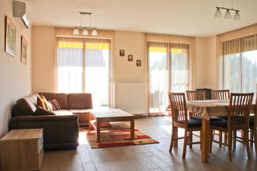 a living room with a couch and a table and chairs at Strand Apartmant in Keszthely