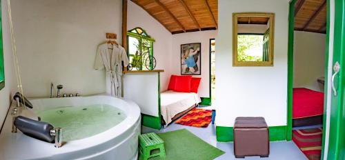 a bathroom with a tub and a bedroom with a bed at Kantarrana Casa de Campo in Jardin