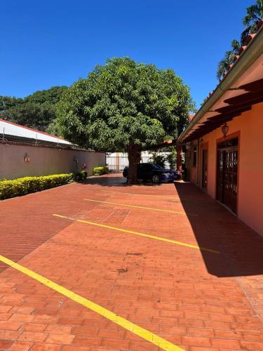 a parking lot with a tree and a building at Gaman Hotel Glamping in Santa Cruz de la Sierra