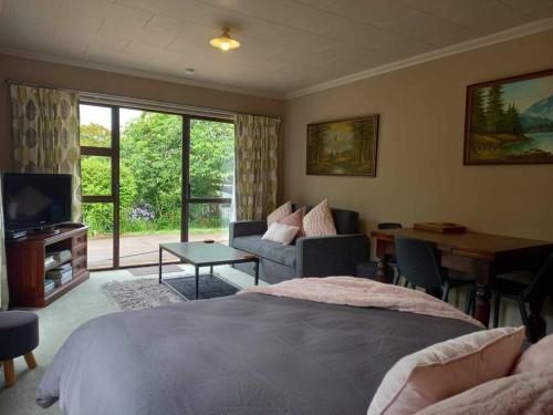 a bedroom with a bed and a couch and a table at Rural life in Otorohanga