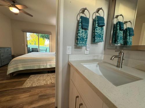 a bathroom with a sink and a bed at Desert Princess Serenity Suite in Cathedral City