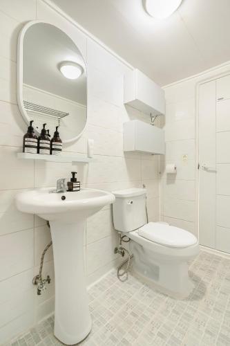 a white bathroom with a toilet and a sink at Emotional, 3type inteior style in Seoul