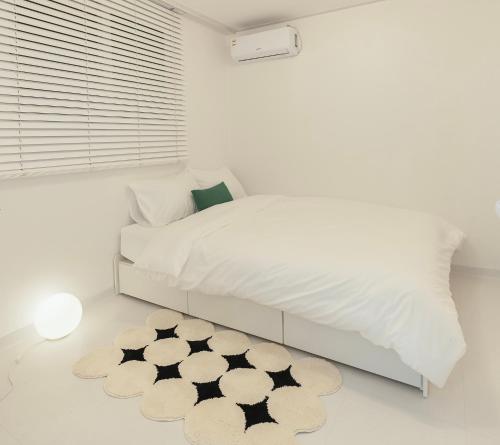 a bedroom with a white bed and a black and white rug at Emotional, 3type inteior style in Seoul