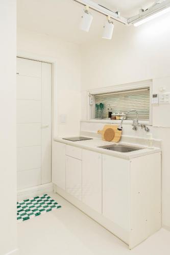 a kitchen with white cabinets and a sink at Emotional, 3type inteior style in Seoul