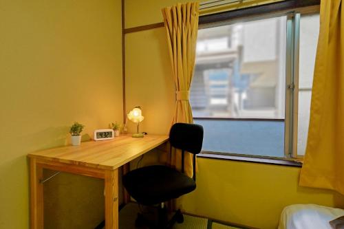 a desk with a mirror and a chair next to a window at 鹿の宿 in Osaka