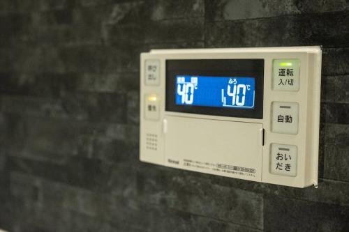 a digital clock hanging on a wall at Osaka Rejoice ST'A'Y-KUROSAKI in Osaka